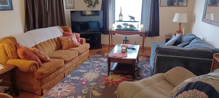 Living room with two couches, one is a sleeper sofa, rocking recliner, coffee table, and TV in Rend Lake Airbnb vacation rental