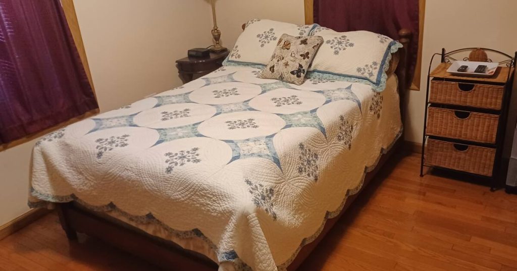 Second Bedroom with queen bed, nightstand, dresser, TV, and extra blankets and pillows in Rend Lake Airbnb vacation rental
