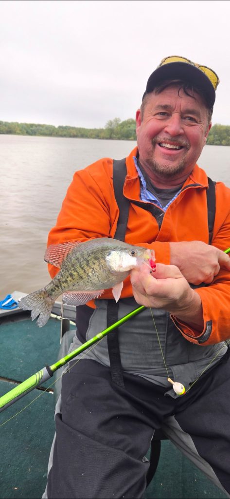 Customer holding a crappie and fishing pole during a guided crappie fishing trip on Rend Lake