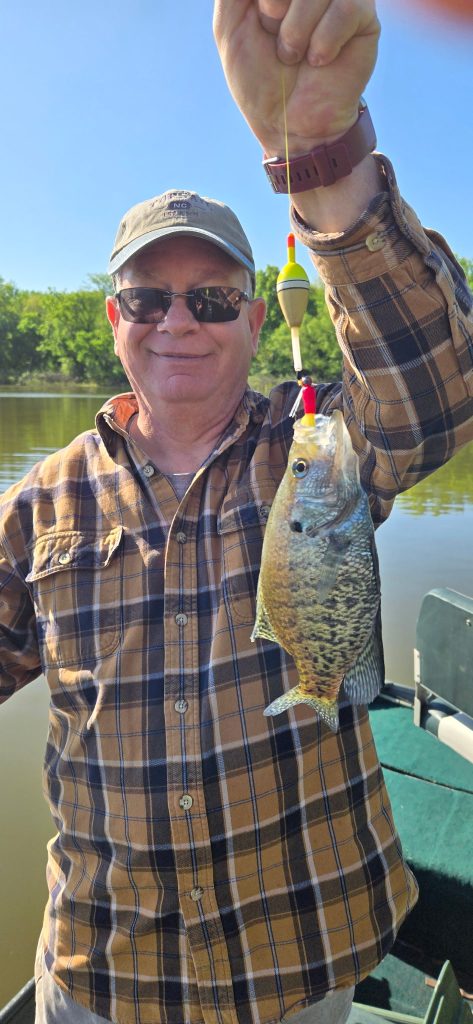 Happy fishing customer holding a crappie caught on Rend Lake during a guided fishing trip
